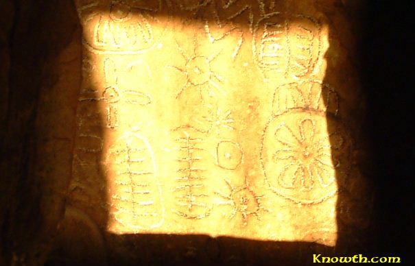 Spring equinox sunbeam on Loughcrew Cairn T backstone, illuminating sunburst and ladder carvings, March 2005.